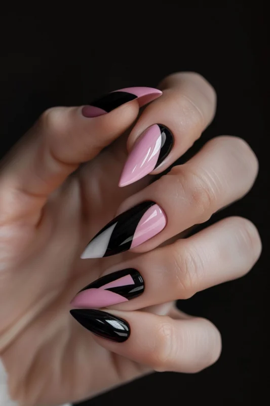 Stiletto nails with pink and black geometric patterns.