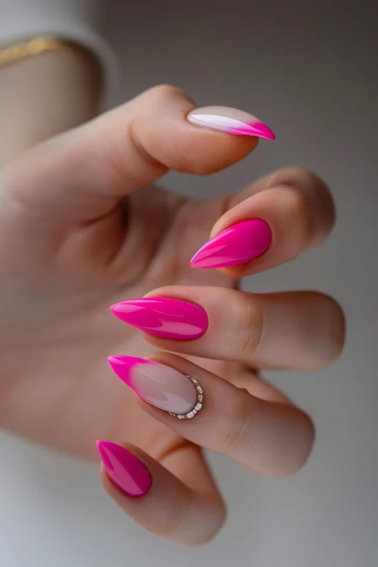 Almond-shaped nails with hot pink French tips and subtle rhinestone details.