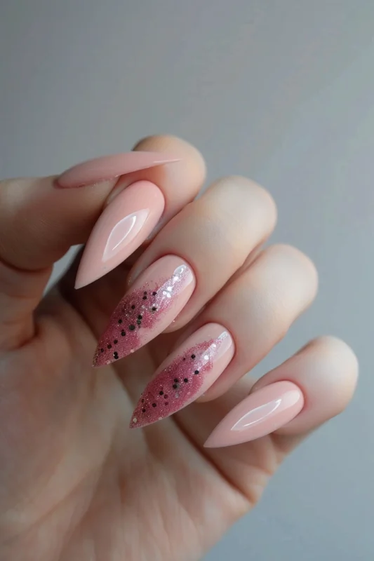 Stiletto nails in pale pink with a few glitter accents.