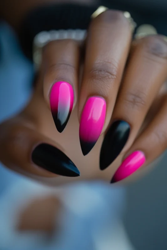 Stiletto-shaped nails with a pink to black ombre French tip.