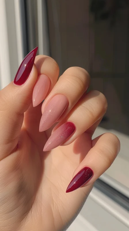 Glossy stiletto nails in burgundy and shimmering pink.