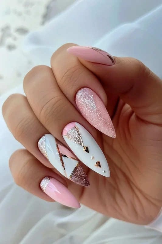 Stiletto nails with white, pink, glitter, and rhinestone accents.