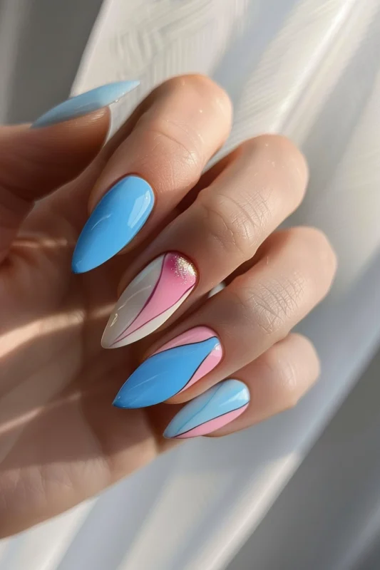 Stiletto nails with blue and pink stripes and a glittery accent.