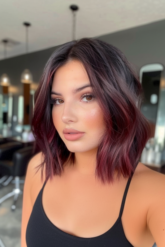 Woman with black hair and subtle burgundy highlights.