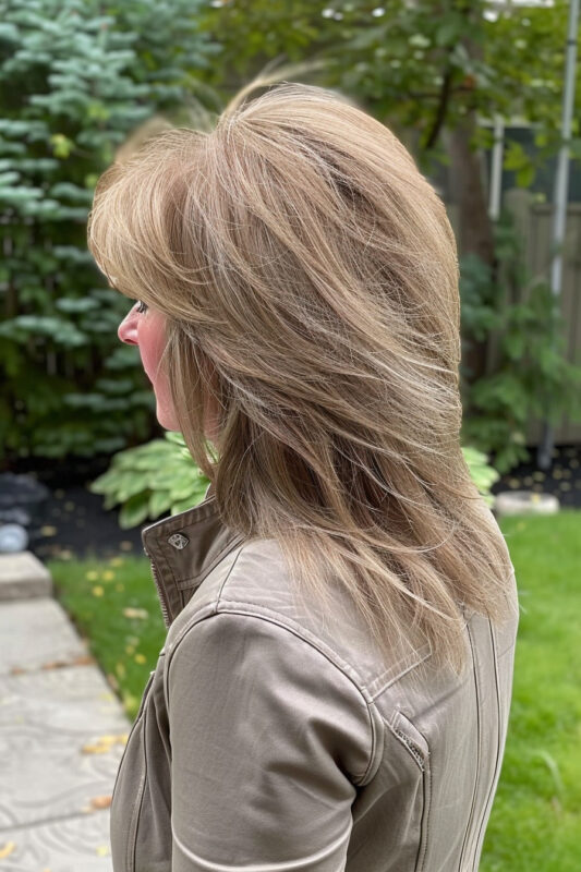 Picture of an older woman with a long shaggy layered haircut.