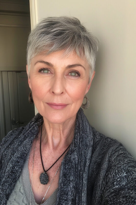 Picture of an older woman with a short pixie haircut with tapered sides.