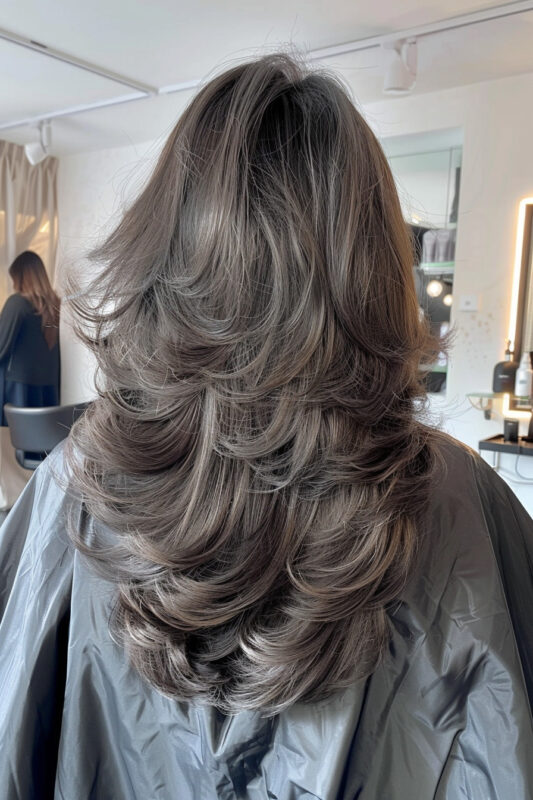 Woman with ash brown butterfly layered hair.