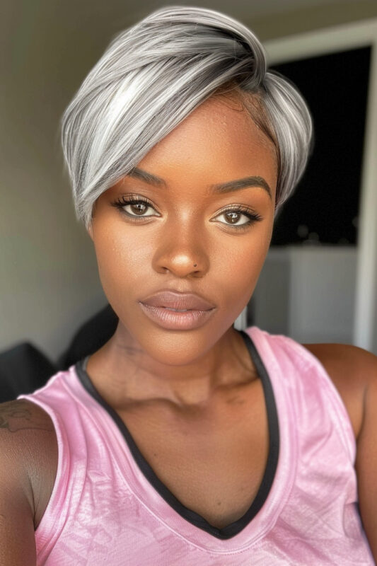 Woman with a silver pixie cut with dark roots and a side-swept fringe.