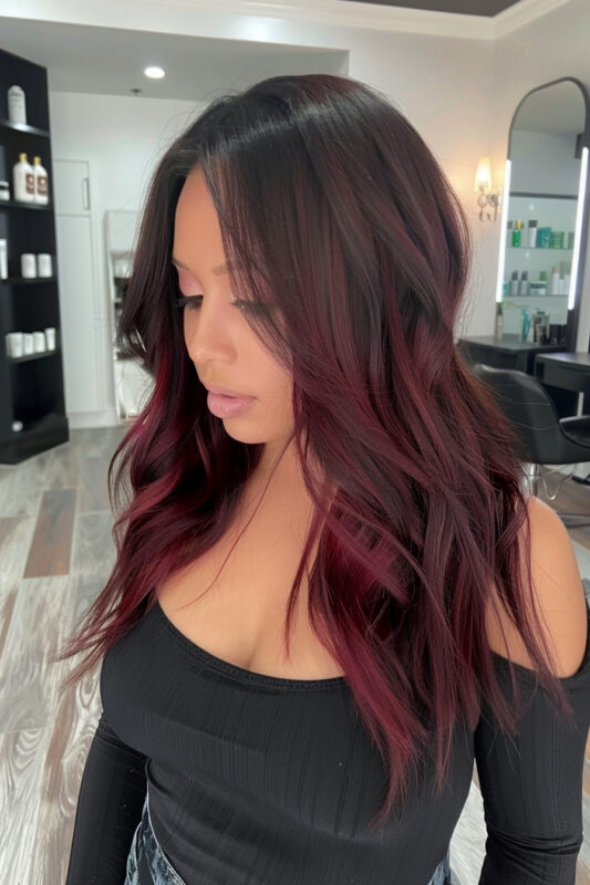 Photo of a woman with light burgundy ombre on dark brown hair.