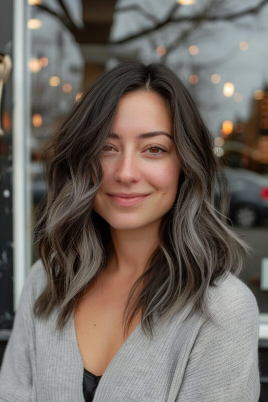 Photo of a woman with silver balayage on dark brown hair.