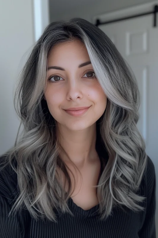 Woman with silver highlights on long wavy dark hair.