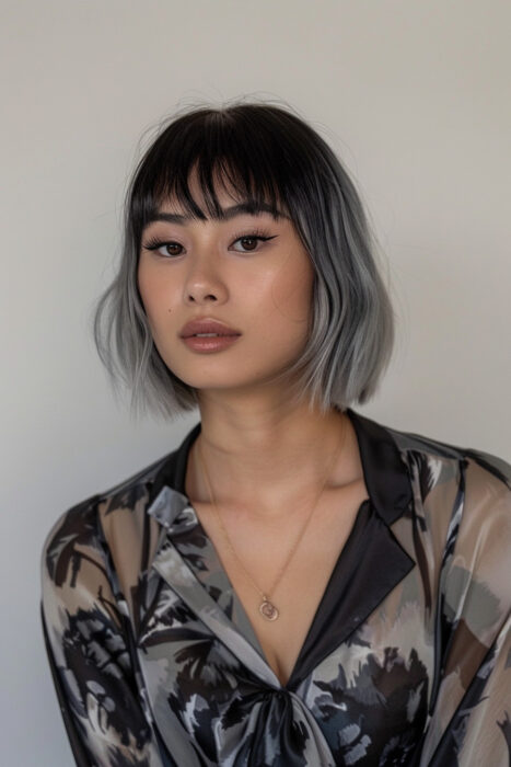 Woman with black and silver hair and bangs.