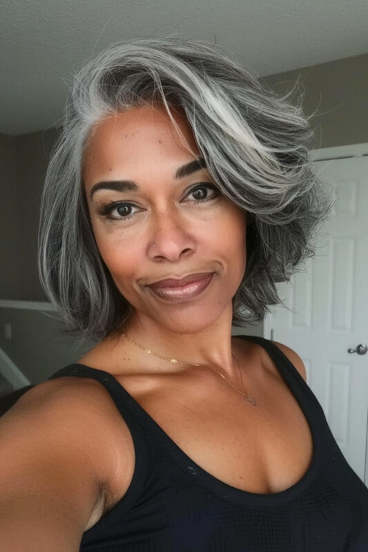 Woman over 50 with a layered bob and deep side part haircut.