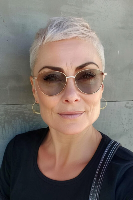 Woman with a platinum pixie haircut with buzzed sides.