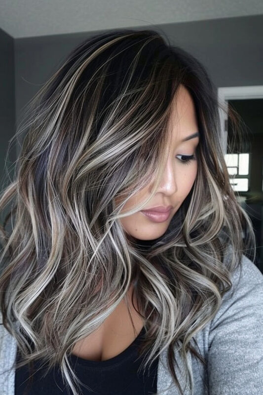 Woman with black hair and an ash blonde balayage.