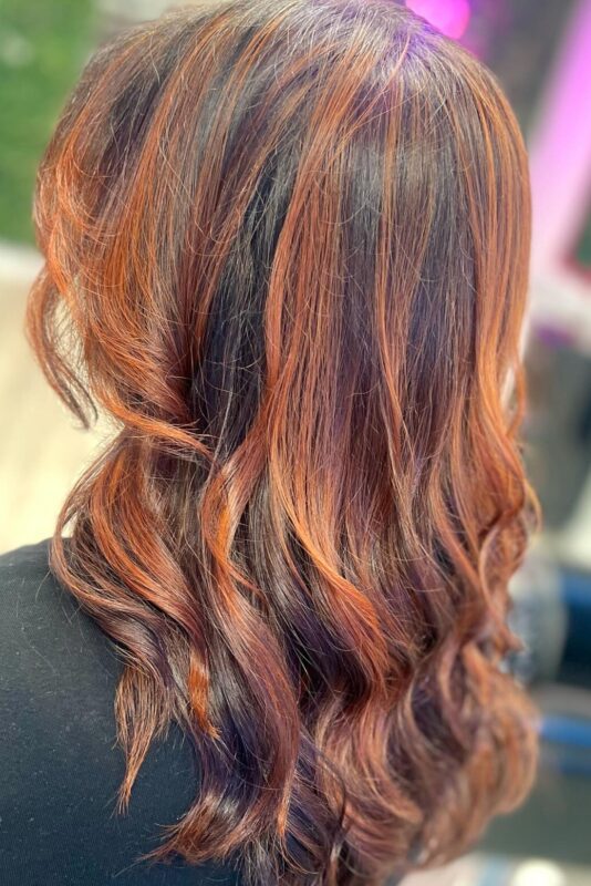 Woman with auburn red hair with copper highlights.