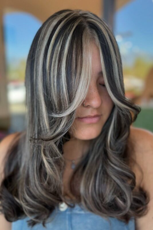 Woman with black hair and icy blonde highlights.