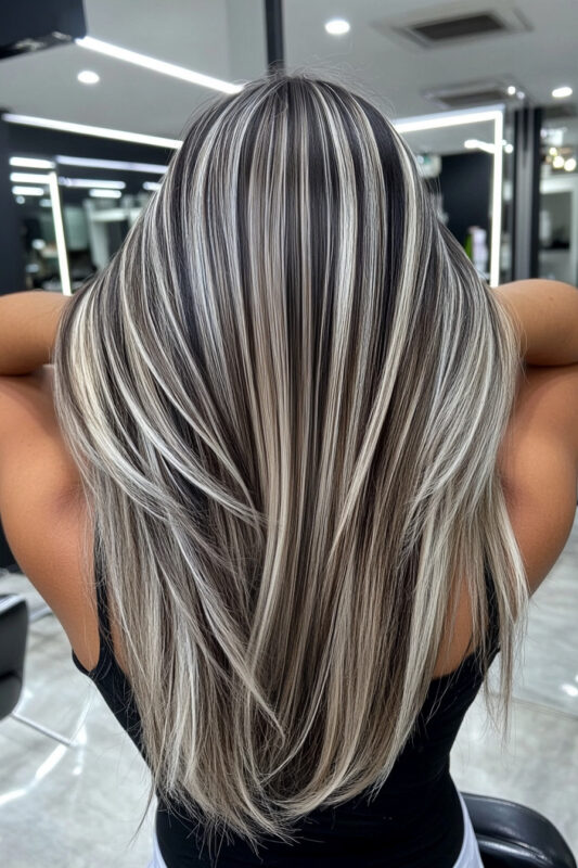 Woman with full platinum highlights on raven black hair.