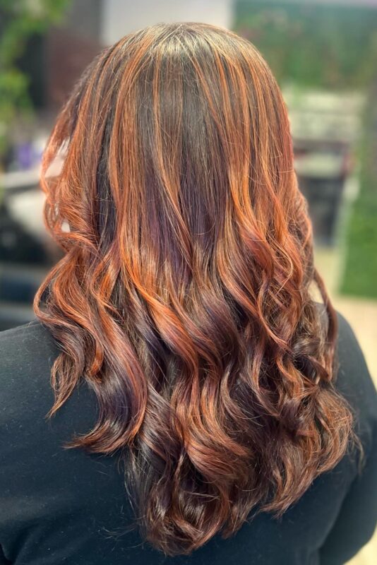 Woman with brown hair and subtle auburn highlights.