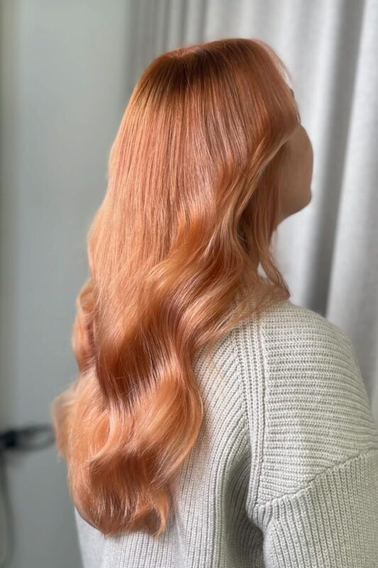 Mujer con cabello color melocotón cobrizo.