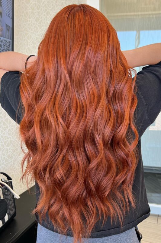 Woman with a bold copper red hair color.