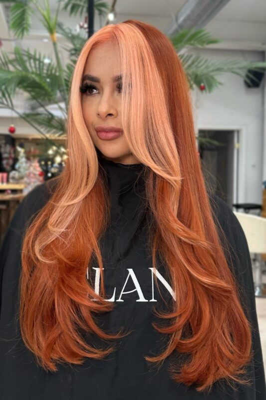 Mujer con cabello color melocotón coral.