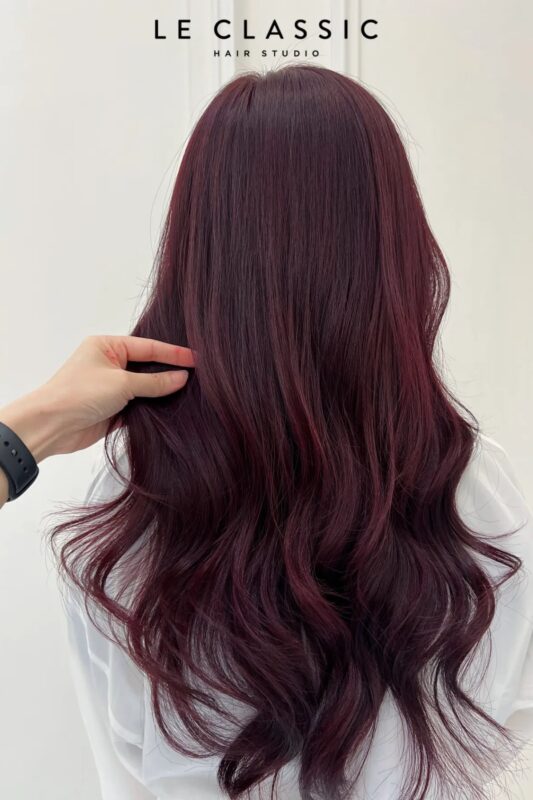 Woman with dark brown hair with burgundy undertones.