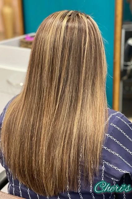 Woman with dark brown hair and honey blonde highlights.