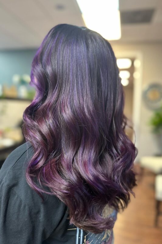 Woman with dark brown hair and purple highlights.