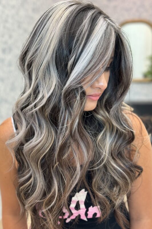 Woman with dark brown hair and white highlights.