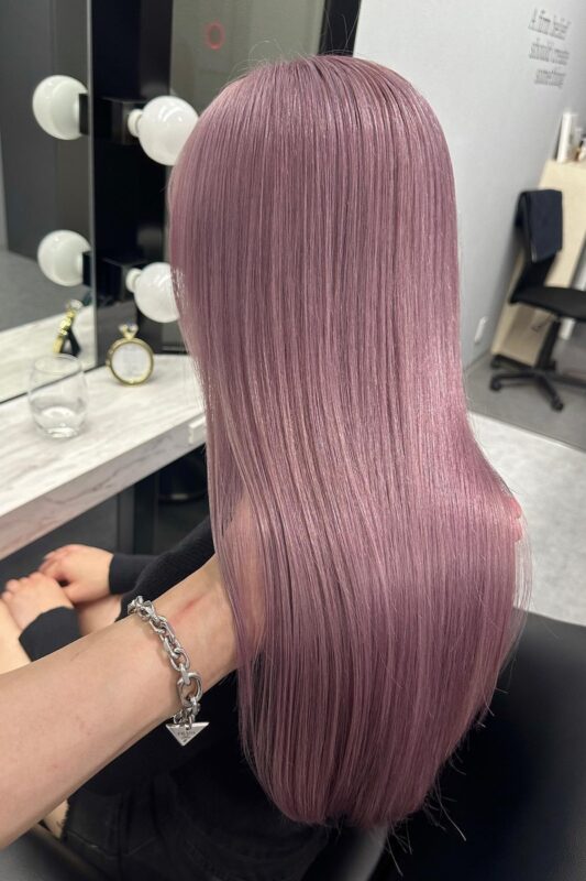 Woman with dark lavender pink hair.