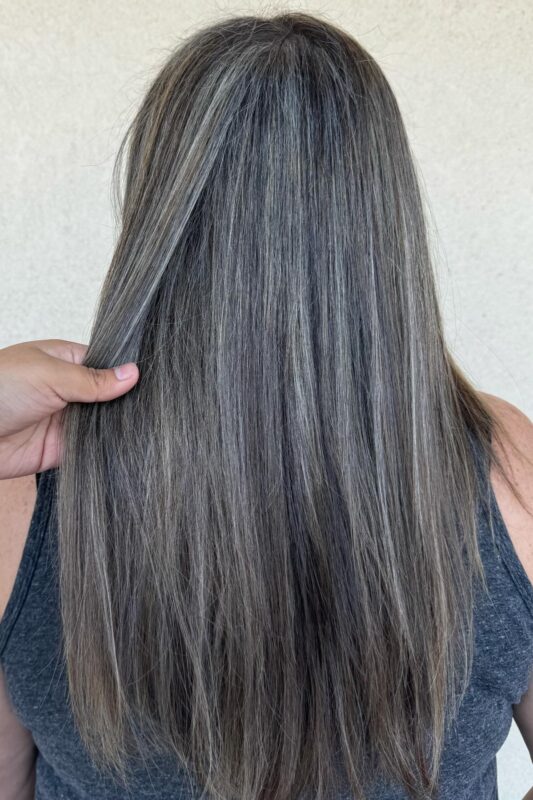 Woman with full grey highlights on brown hair.