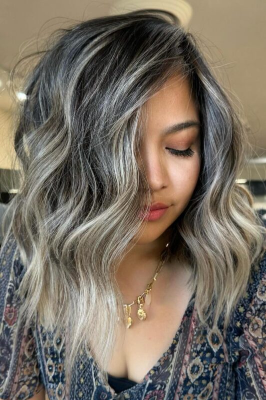 Woman with high contrast blonde balayage on dark hair.