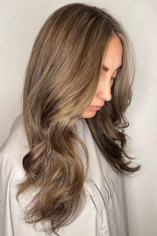 Woman with light brown hair and blonde highlights.