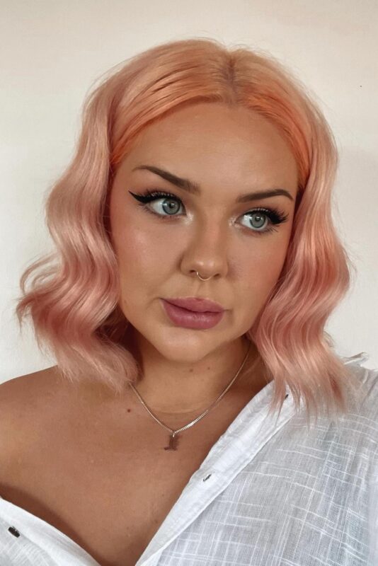 Woman with a pastel peach hair color.