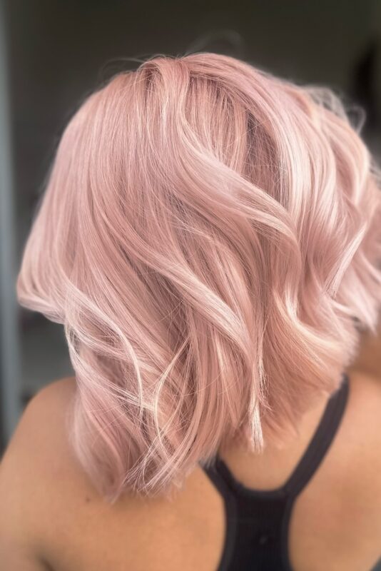 Woman with a pastel pink peach hair color.