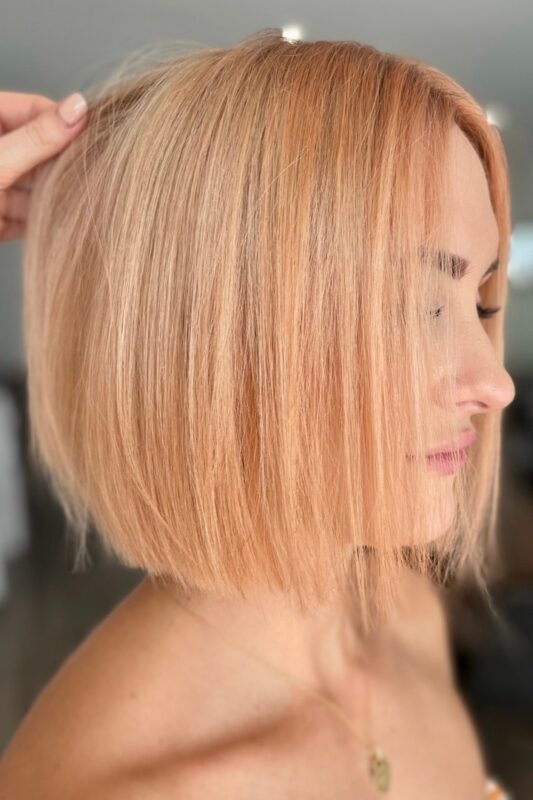 Mujer con cabello color rubio melocotón.