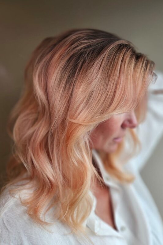 Mujer con un peinado ombre de pelo melocotón.