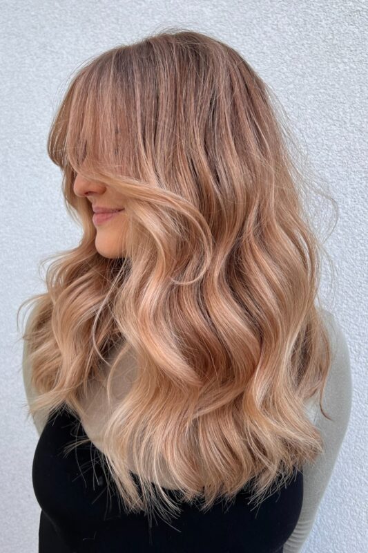 Mujer con cabello rubio melocotón.