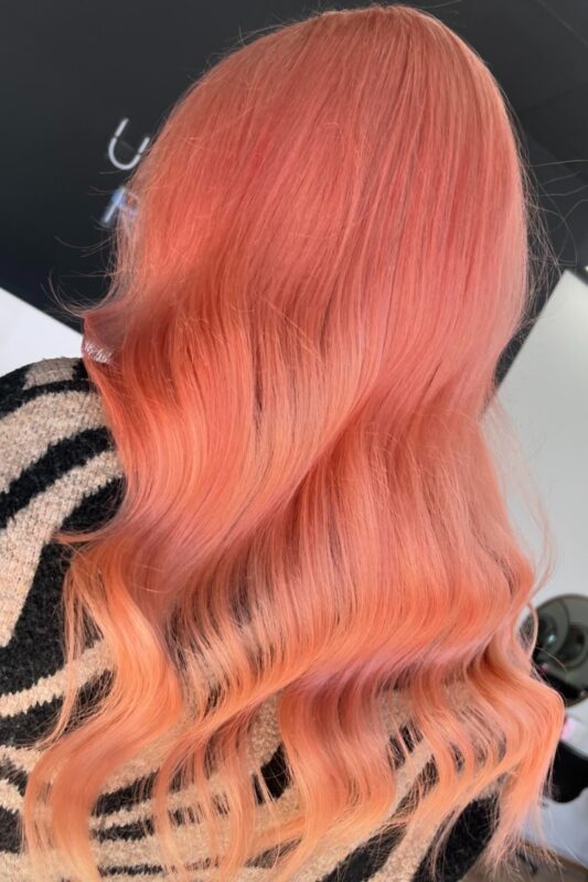 Woman with a peachy sunset hair color.