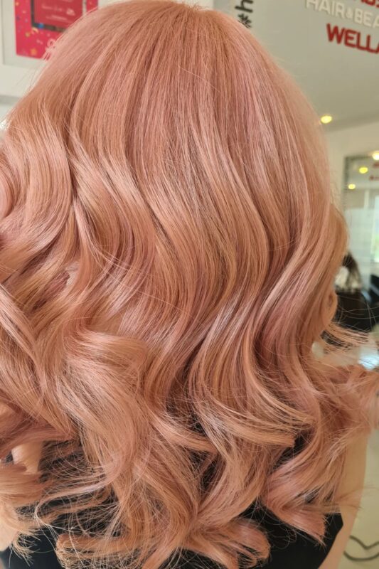 Mujer con cabello color melocotón dorado rosa.