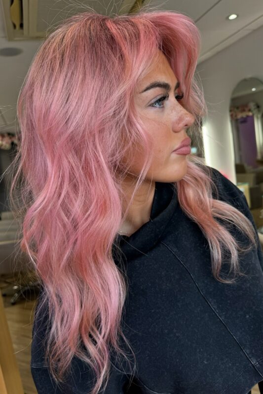 Woman with rose gold pink hair.