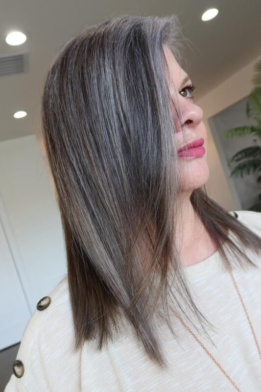 Woman with silvery gray highlights blended with her dark hair.