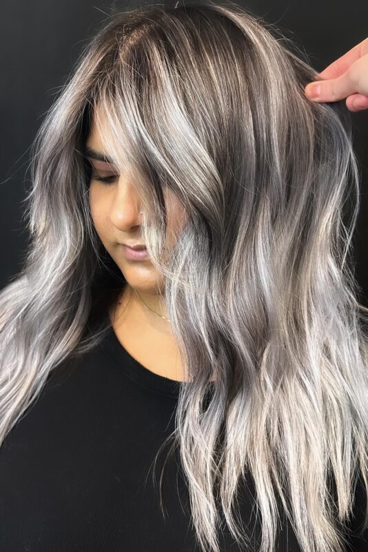 Woman with expertly applied silvery white highlights on brown hair.