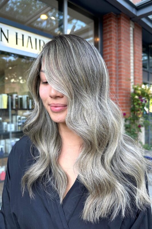 Woman with cool-toned silver platinum highlights on her black hair.