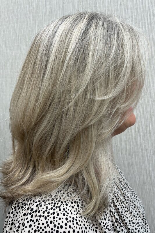 Bright blonde highlights blending grays for a vibrant, youthful look.