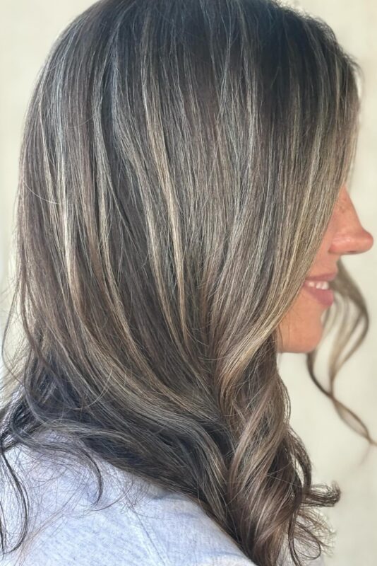 Blonde and grey highlights for brown hair blending in an elegant, low-maintenance style.