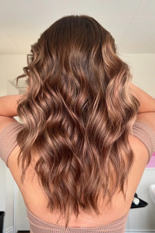 Woman with a golden balayage on her brown hair.