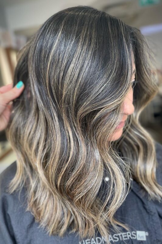 Dark hair enhanced with golden blonde highlights to hide gray.