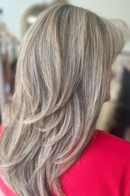 Gray hair blending with cool blonde highlights for an effortless style.